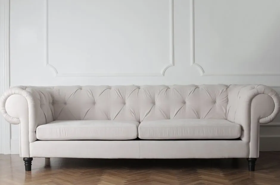 Luxurious white sofa in a modern minimalist interior with wooden flooring.